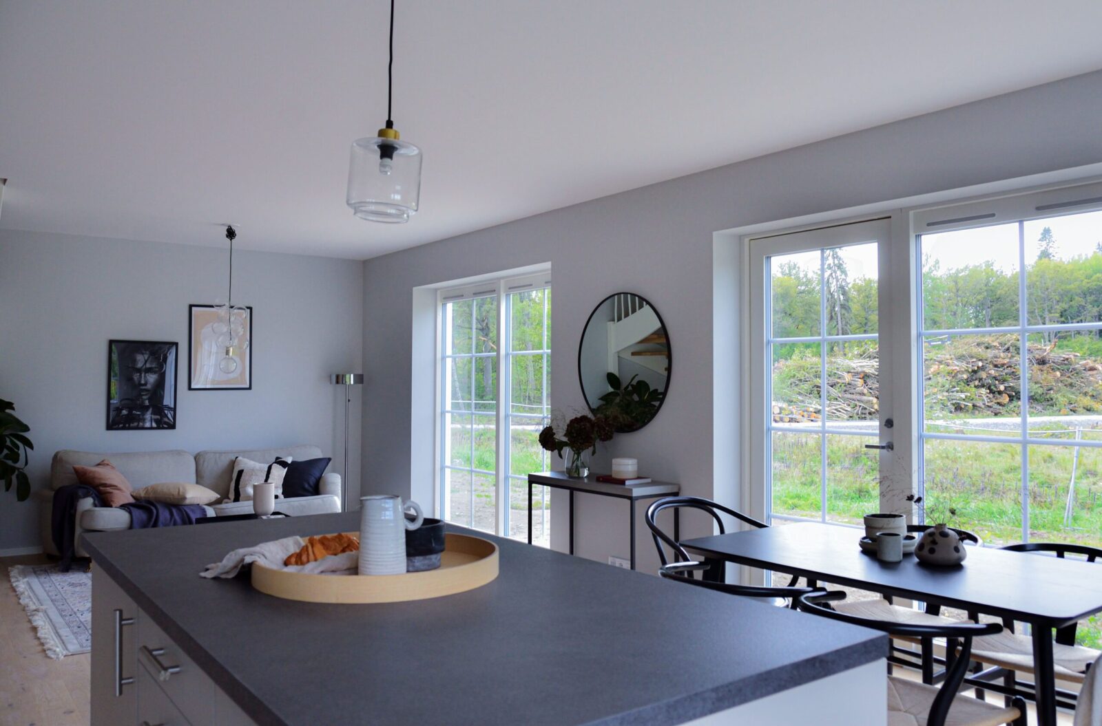 Köksö och matbord i elegant modern lägenhet med bekväm soffa och stora fönster
